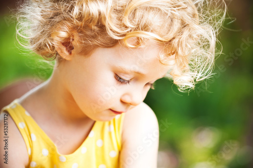Photo: Adorable little girl taken closeup outdoors in summer Adorable little girl taken closeup outdoors in summer