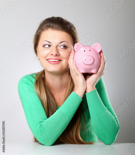Photo: Young beautiful woman with piggy bank Young beautiful woman with piggy bank