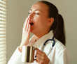 The  yawning woman  near window and holding cup