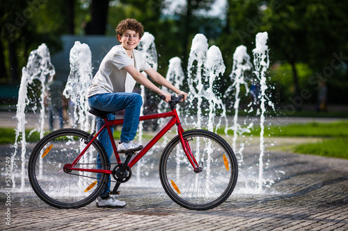 Photo: Urban biking - teenage boy and bike in city Urban biking - teenage boy and bike in city