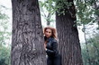 Woman posing between trees