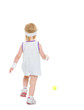 Photo: Baby running for tennis ball . rear view Baby running for tennis ball . rear view