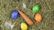 A hand cvollects a few estaer eggs from a pile of straw.