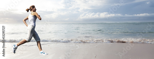 Photo: Woman running on the beach. Woman running on the beach.