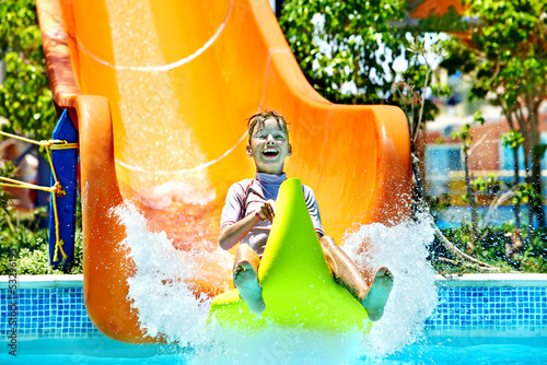 Photo: Child on water slide at aquapark. Child on water slide at aquapark.