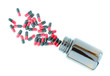 Red-black pills with brown bottle on white background