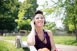 beautiful hipster short hair woman listening music in the park