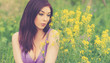 girl sitting in a summer field with flowers