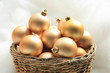 Golden Christmas ornaments in a wicker basket