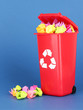 Recycling bin with papers on blue background