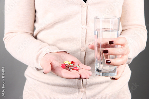 Photo: Many pills and glass water in hand Many pills and glass water in hand
