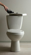 Hand hides gun in toilet tank in a bathroom