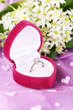 Beautiful box with wedding ring on purple background