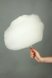 Hand holding stick with cotton candy, on color background