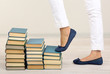 Girl climbs up on pile of books