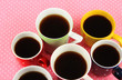 Many cups of coffee on pink napkin