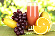 Glass of fresh juice on table on bright background