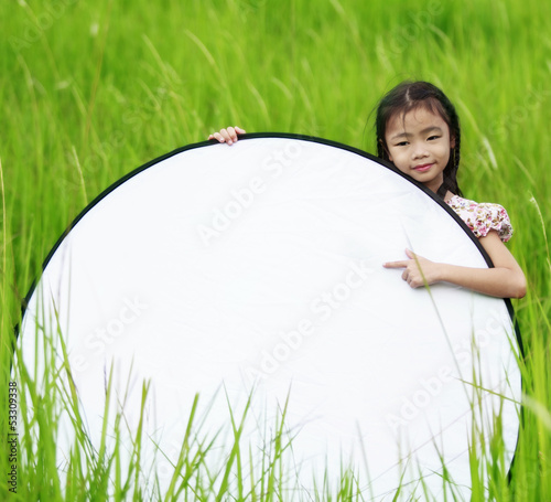 Photo: Cute little girl on neutral background holding sign Cute little girl on neutral background holding sign