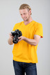 Handsome photographer with camera,on gray background