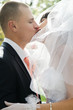 Groom kissing bride in lips outdoors