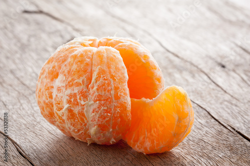 Photo: Raw skinned mandarin on wooden table Raw skinned mandarin on wooden table