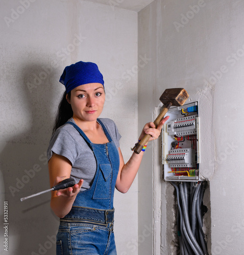 Photo: Woman with an electrical box, mallet and hammer Woman with an electrical box, mallet and hammer