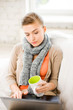 Foto: diseased woman in scarf using laptop at home diseased woman in scarf using laptop at home