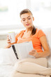 woman with cup of coffee reading magazine at home