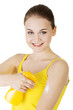 Young woman using sun protection cream.
