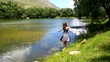 Young  girl in a dress dances on the shore of a mountain lake