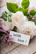 Postcard with elegant  flowers and tag with words With love