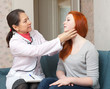 female doctor touching neck of teen