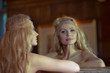 Photo: Beautiful blonde woman looking in the mirror Beautiful blonde woman looking in the mirror