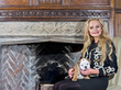 Photo: Woman sitting by a fireplace with a dog puppy Woman sitting by a fireplace with a dog puppy