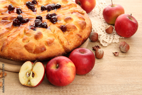 Photo: tasty homemade pie with jam and apples, on wooden table tasty homemade pie with jam and apples, on wooden table