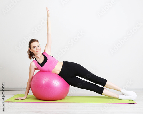 Photo: Portrait of beautiful young woman exercises with gym ball Portrait of beautiful young woman exercises with gym ball