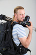 Portrait of handsome photographer with camera and tripod,