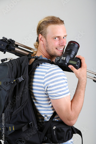 Photo: Portrait of handsome photographer with camera and tripod, Portrait of handsome photographer with camera and tripod,