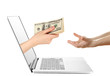 Hand giving money from laptop screen isolated on white
