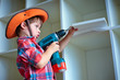 Cute little boy using an electric screwdriver