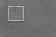 Vent window on gray concrete wall