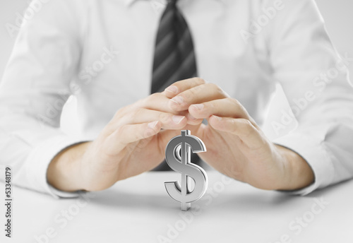 Photo: hands covering dollar hands covering dollar