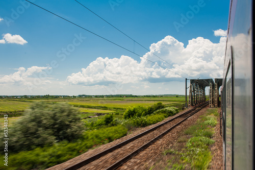 Photo: railway goes to horizon in green and yellow landscape railway goes to horizon in green and yellow landscape