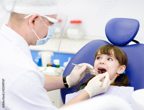 Photo: dental examining being given to little girl by dentist dental examining being given to little girl by dentist