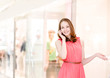 Young woman talking on the phone at the mall