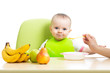 mother spoon feeding baby girl