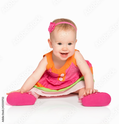 Photo: happy little baby girl in bright multicolored festive dress isol happy little baby girl in bright multicolored festive dress isol