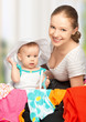 mother and baby girl with suitcase and clothes ready for traveli
