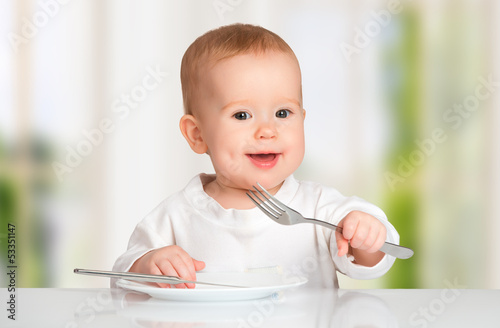 Photo: Funny baby with a knife and fork eating food Funny baby with a knife and fork eating food