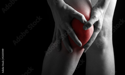 Photo: pain in the knee. Chiropractor doing massage in sick knee in red pain in the knee. Chiropractor doing massage in sick knee in red